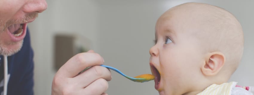 Father spoon feeding baby