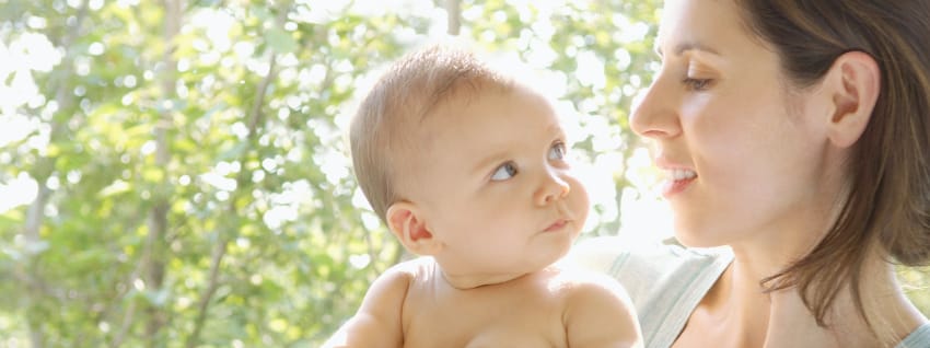 Mother holding baby child in the sunshine, a natural source of vitamin D