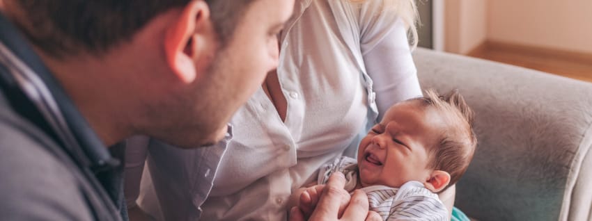 Mother and crying baby with healthcare professional