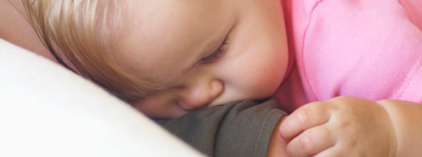 Baby asleep on mother&apos;s shoulder