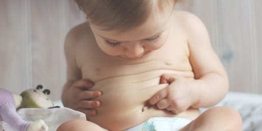 Baby sat and looking at his belly
