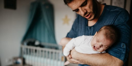 Parent holding infant suffering from reflux