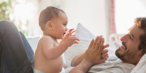 Father and baby playing and smiling