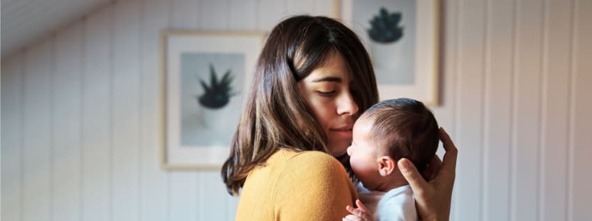 a mother experiencing feeding issues and holding her baby