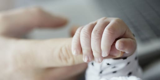 Baby holding parent finger
