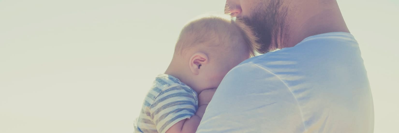 Father gently holding his baby, symbolizing comfort and care for infants with functional gastrointestinal disorders.