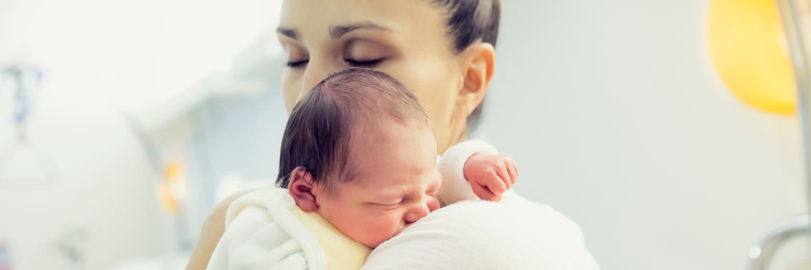 Mother gently holding her baby, symbolizing comfort and care for infants experiencing constipation.