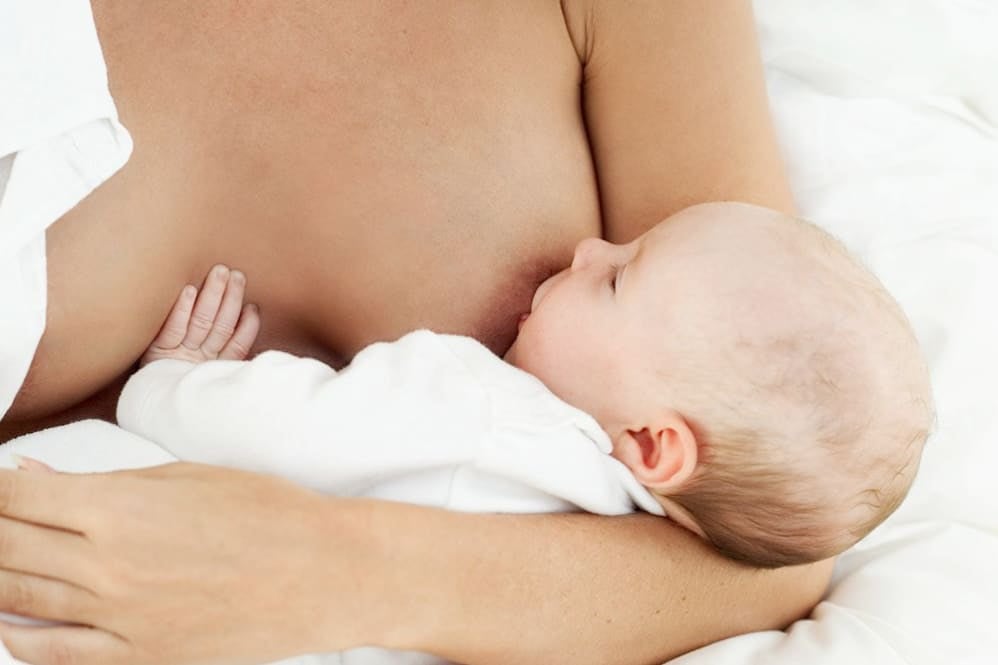 Mother cradling her baby whilst breastfeeding
