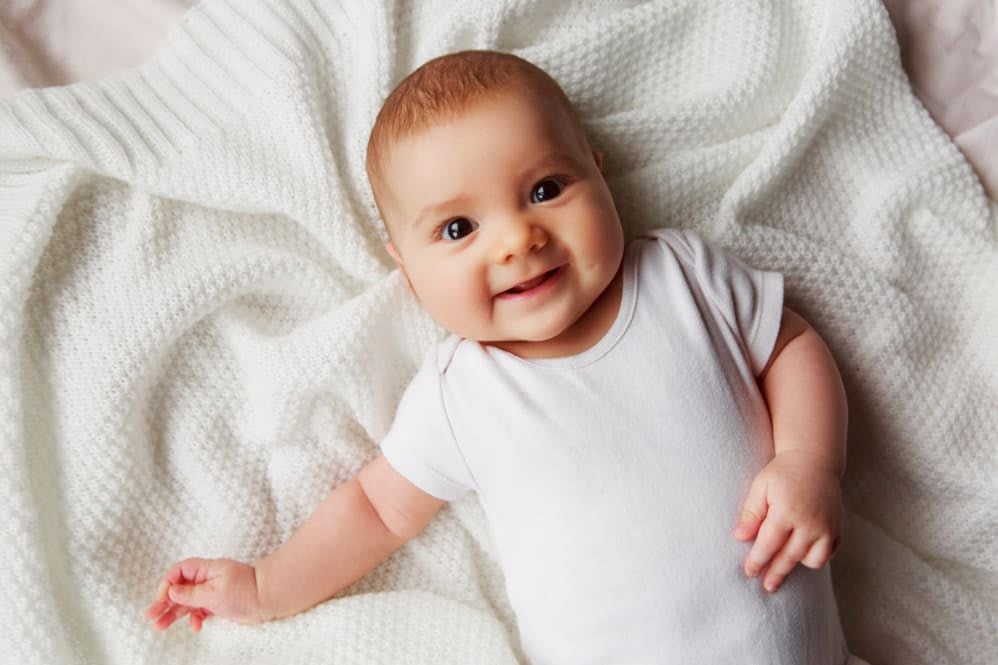 baby lying on back smiling