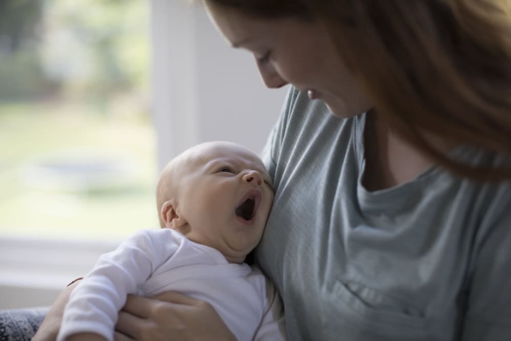 Baby looking up at mum and yawning