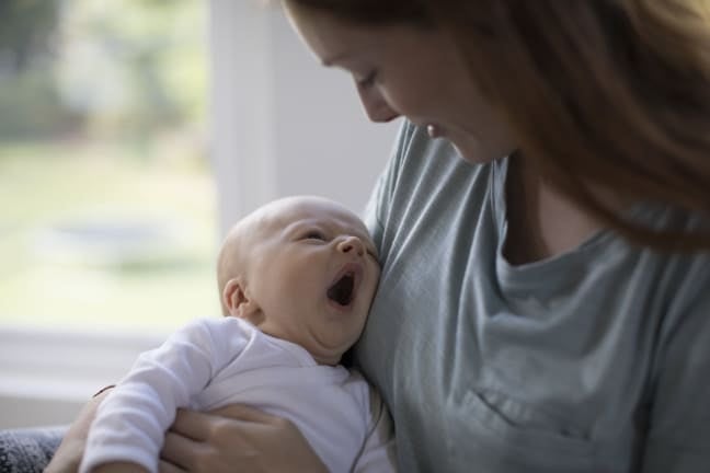 Baby looking up at mum and yawning