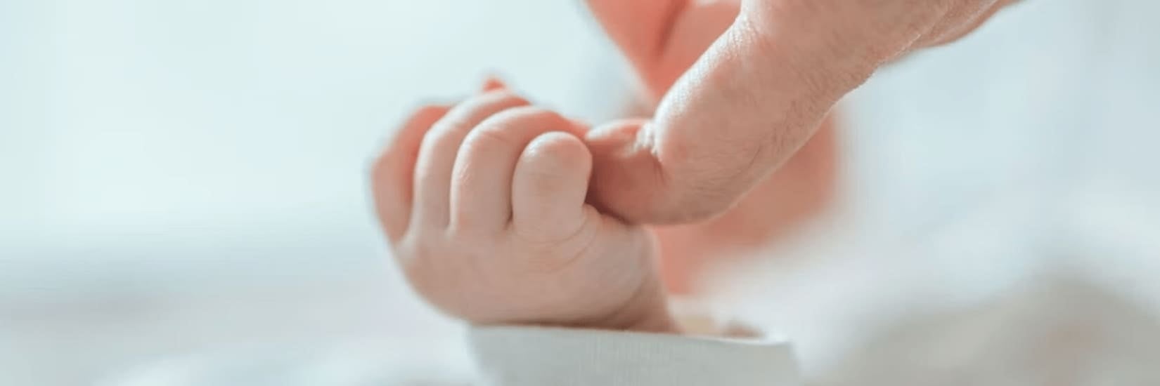 Baby gripping parent finger