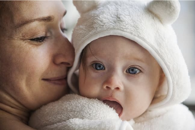 Mother holding baby and smiling