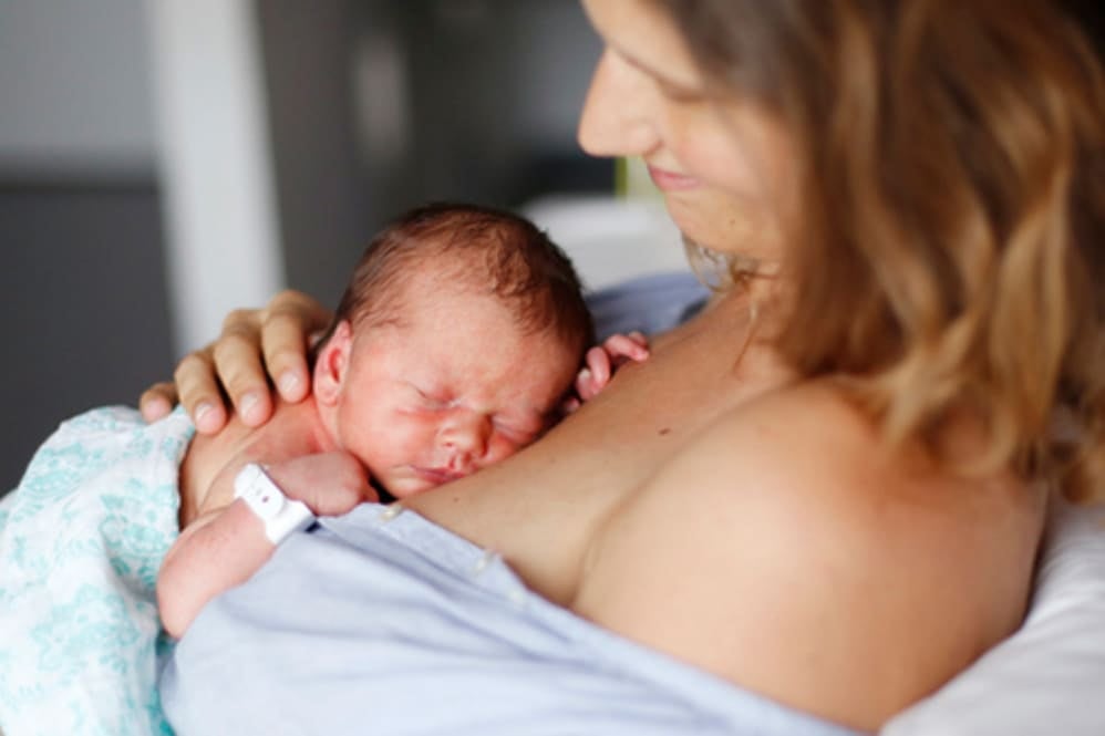 A mother holding her newborn child against her chest
