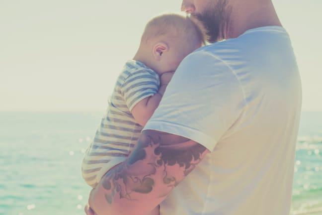 Father gently holding his baby, symbolizing comfort and care for infants with functional gastrointestinal disorders.