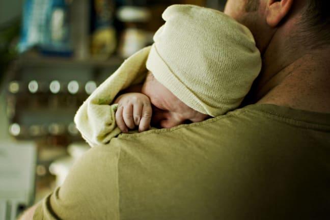 Parent gently comforting their colicky baby