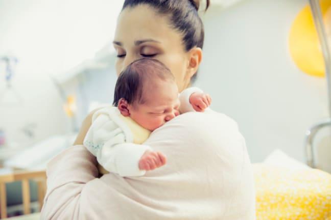 Mother gently holding her baby, symbolizing comfort and care for infants experiencing constipation.