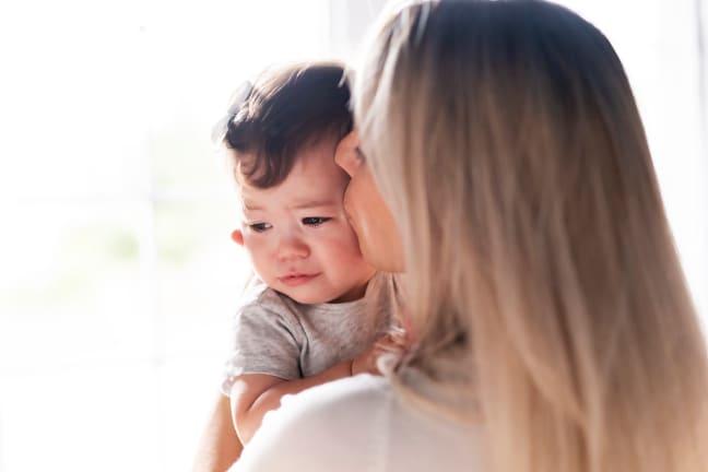 A mother comforting her baby with feeding issues