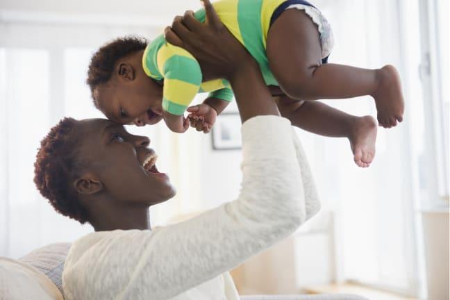 Joyful parent holding child and smiling