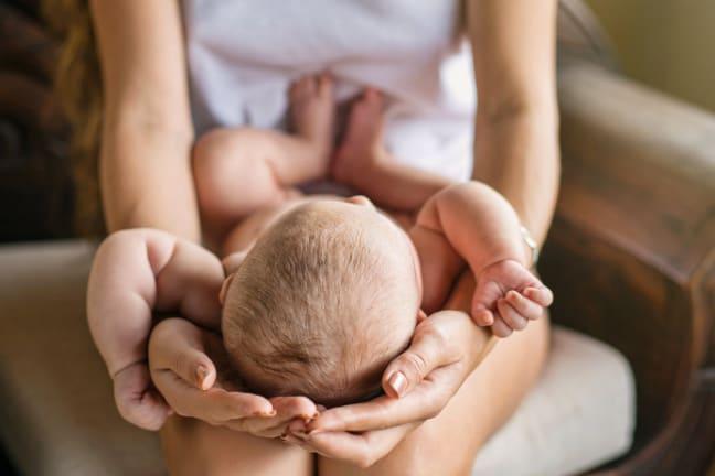 Mother cradling babies head on her lap