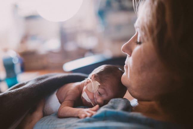 A mother holds her preterm baby to her